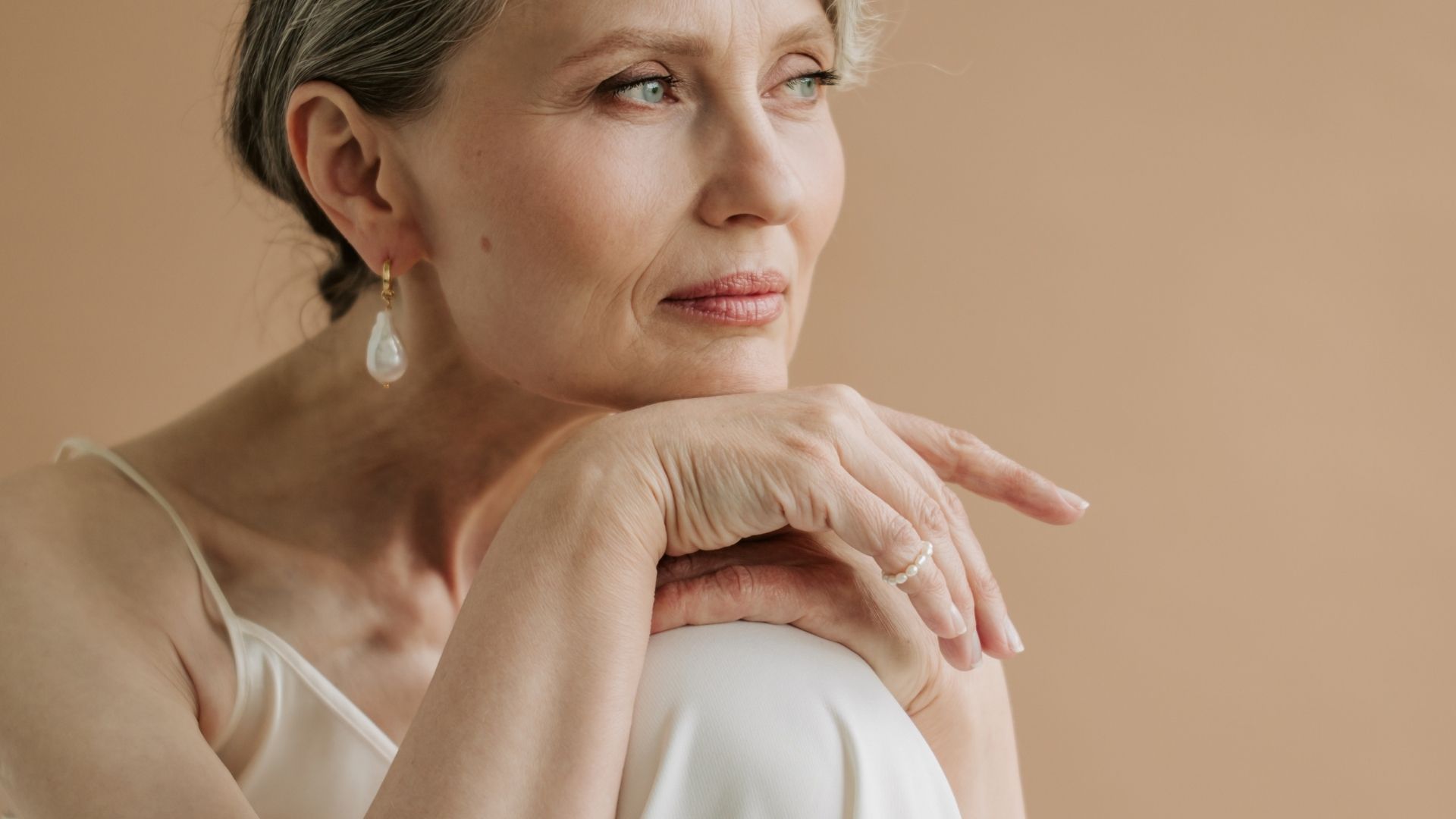 Gold and diamond jewelry on a soft neutral background